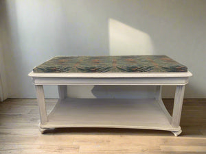 A padded wooden bench with a green upholstered seat and a white painted base.