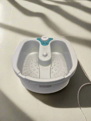 White foot bath with control panel on a light-colored floor