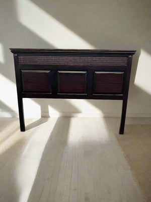 Dark wooden headboard with three square panels on a light wooden floor.
