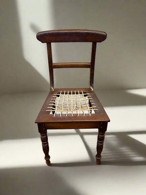 Wooden chair with woven seat on a plain background