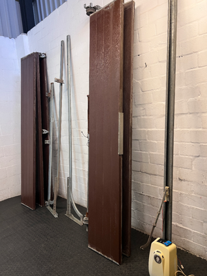 Brown Metal Sectional Garage Door with Motor and Tracks — One Door With Snapped Tensioner; Both Motors Working