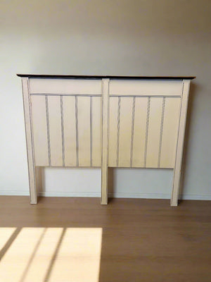Wooden headboard against a white brick wall