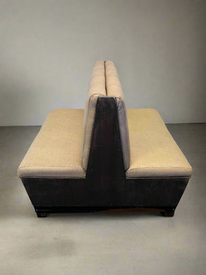 Beige sectional sofa against a white brick wall.