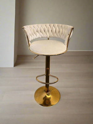 Decorative stool with tufted backrest and gold base on a neutral background
