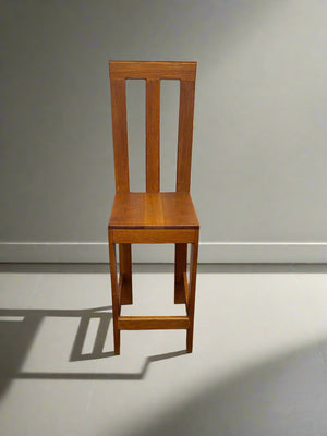 Wooden chair against a plain wall with a light gray floor.