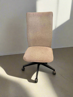 Beige office chair with a high backrest on a plain floor.