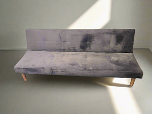 Gray upholstered bench against a plain wall