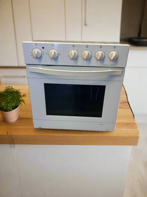 White oven on a wooden countertop with a plant in the background