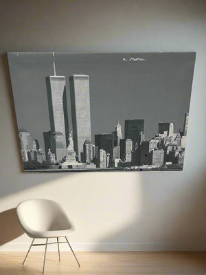 Cityscape artwork on a wall with a chair in front