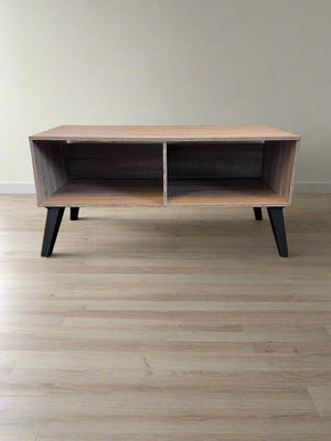 Wooden coffee table with black legs on a wooden floor