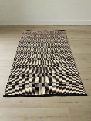 Stylish Black and White Woven Area Rug - Minimalist Design, Slight Wear