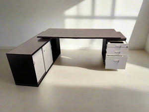 Modern L-shaped desk with storage cabinets on a plain background