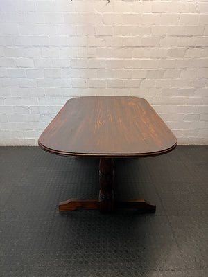 Rounded Brown Timber Dining Table with Pedestal Base — Visible Wear on Tabletop – top view