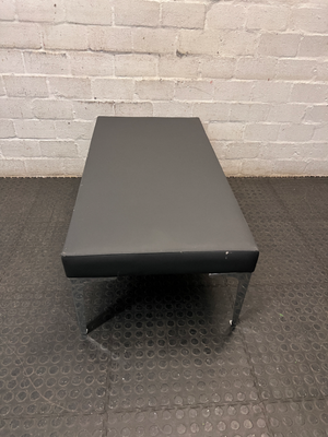 Black Upholstered Bench with Chrome Legs — Fair Condition with Visible Wear