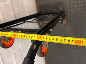 Black Metal Platform Trolley with Mesh Base — Fair Used Condition with Visible Wear