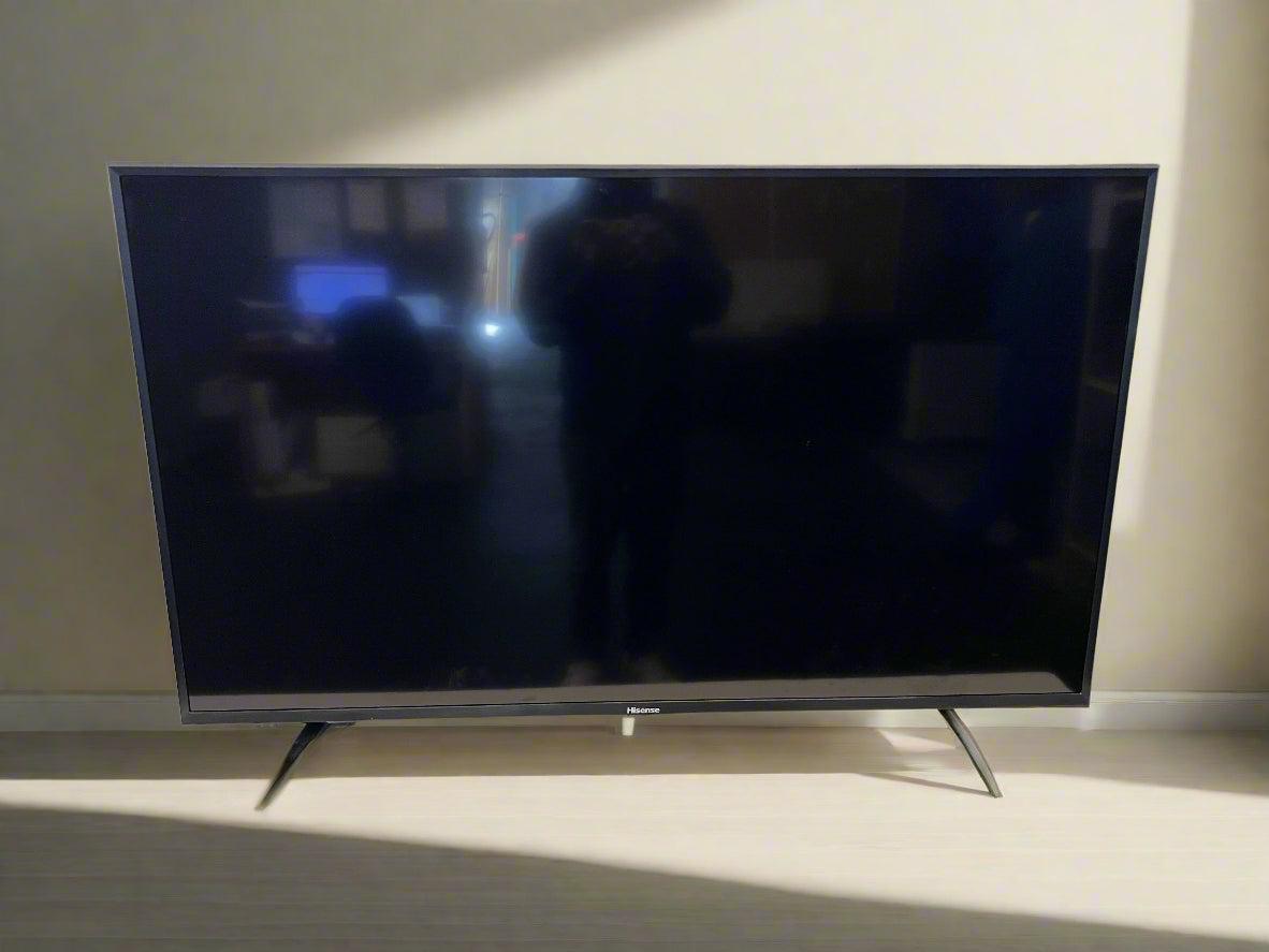 Flat-screen TV on a stand against a plain wall