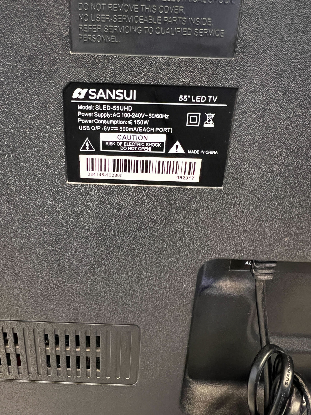 Back of a Sansui LED TV with label and power cord.