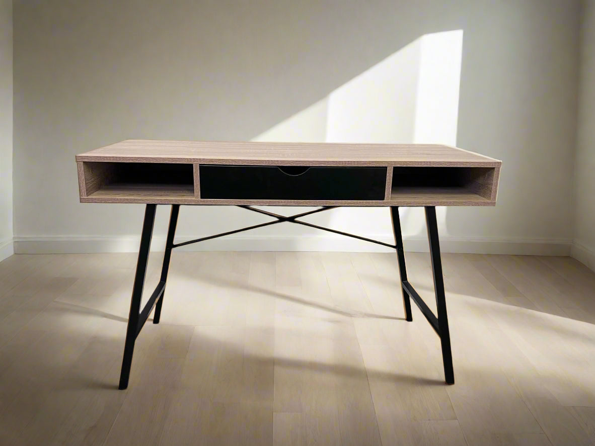 A wooden writing desk with a black drawer and black frame and legs, against a white background.