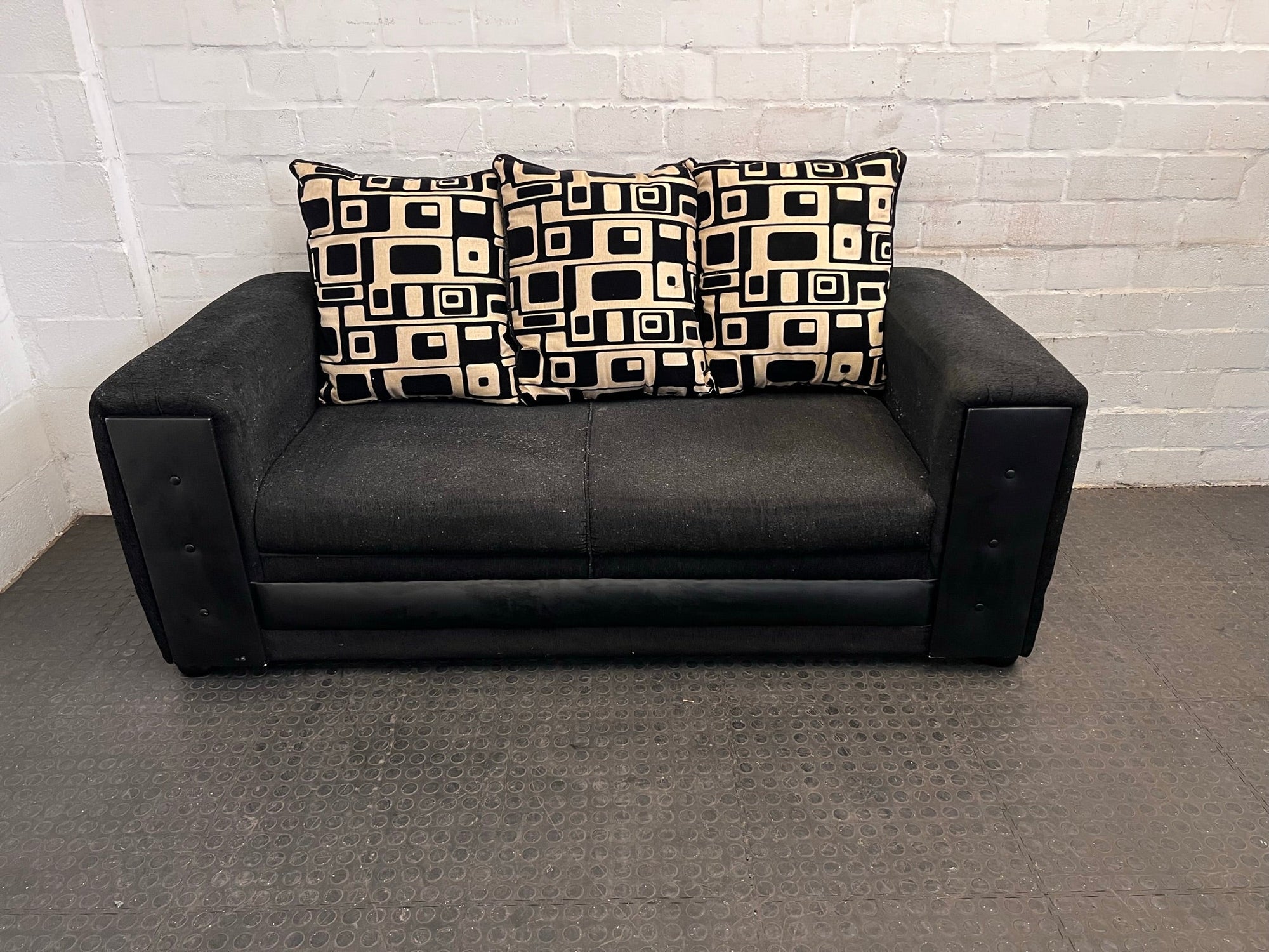 Black Fabric Three Seater Couch with Black and Beige Patterned Cushions
