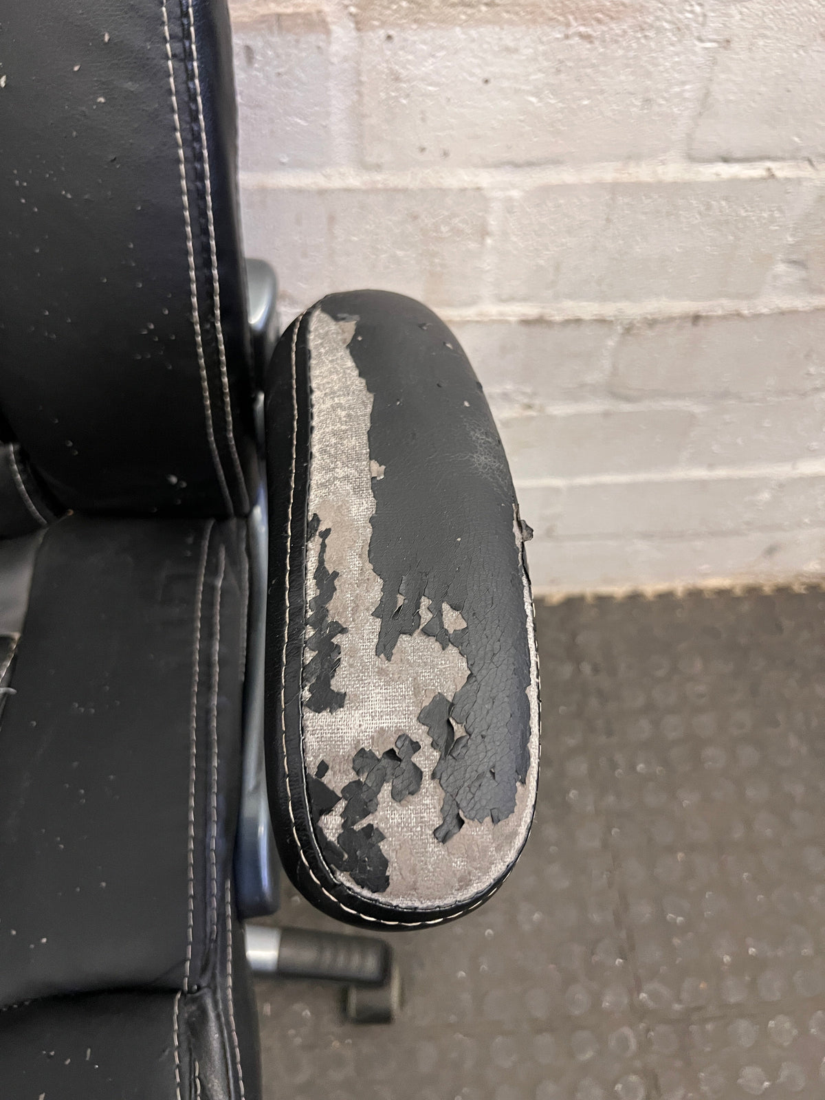 Black Padded Office Armchair on Wheels (Peeling Pleather)