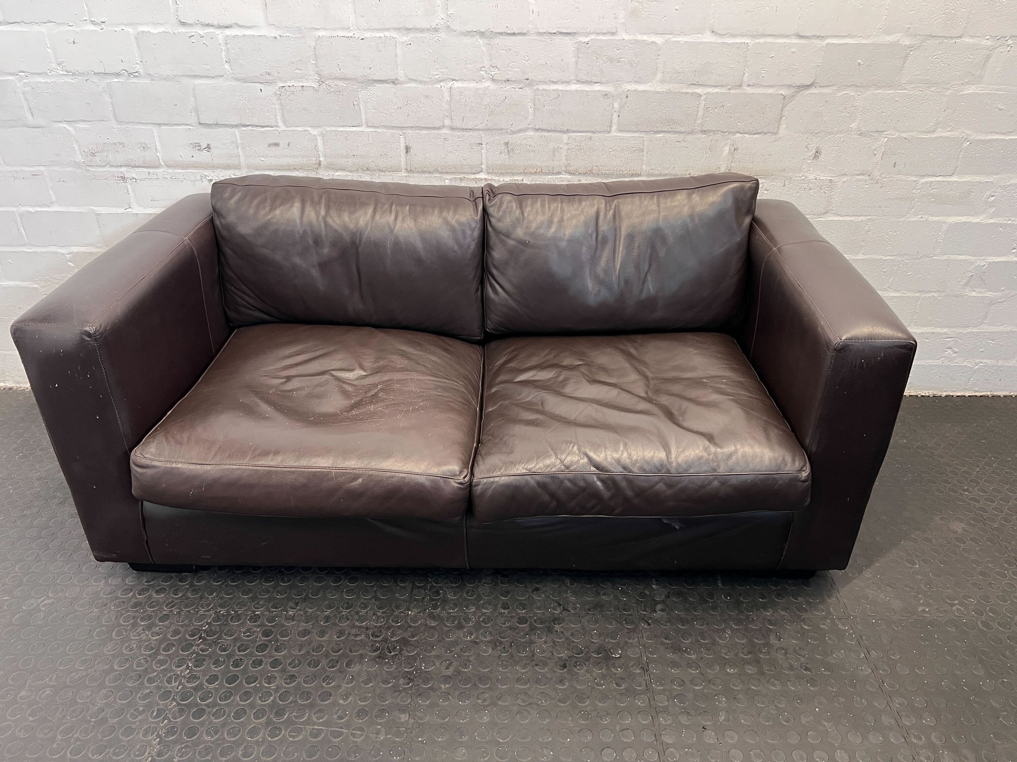 Stylish 2-Seater Brown Leather Couch with Wear on Arm and Base