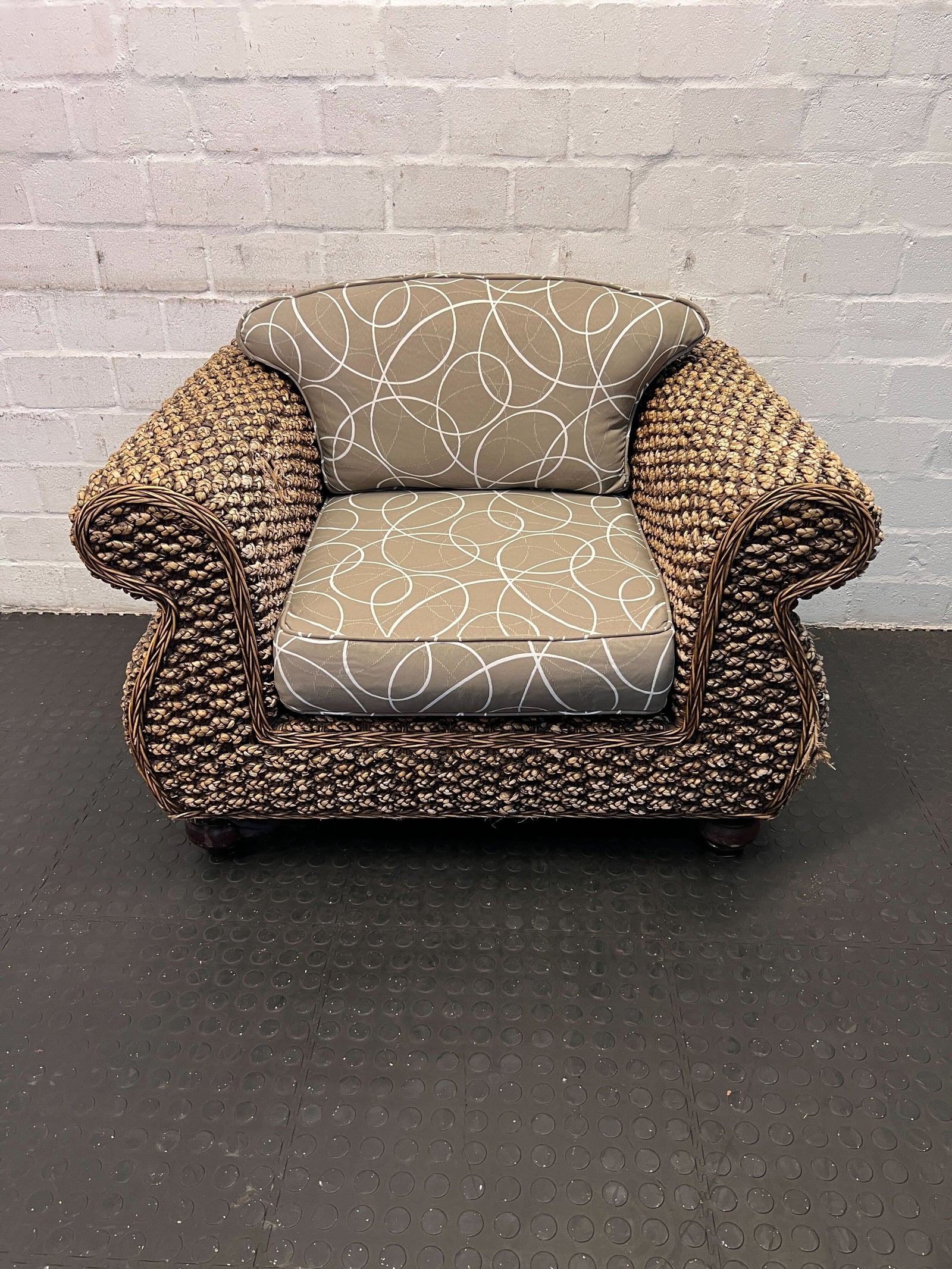 Chic Rattan Armchair with Beige Cushion and Curvy Design