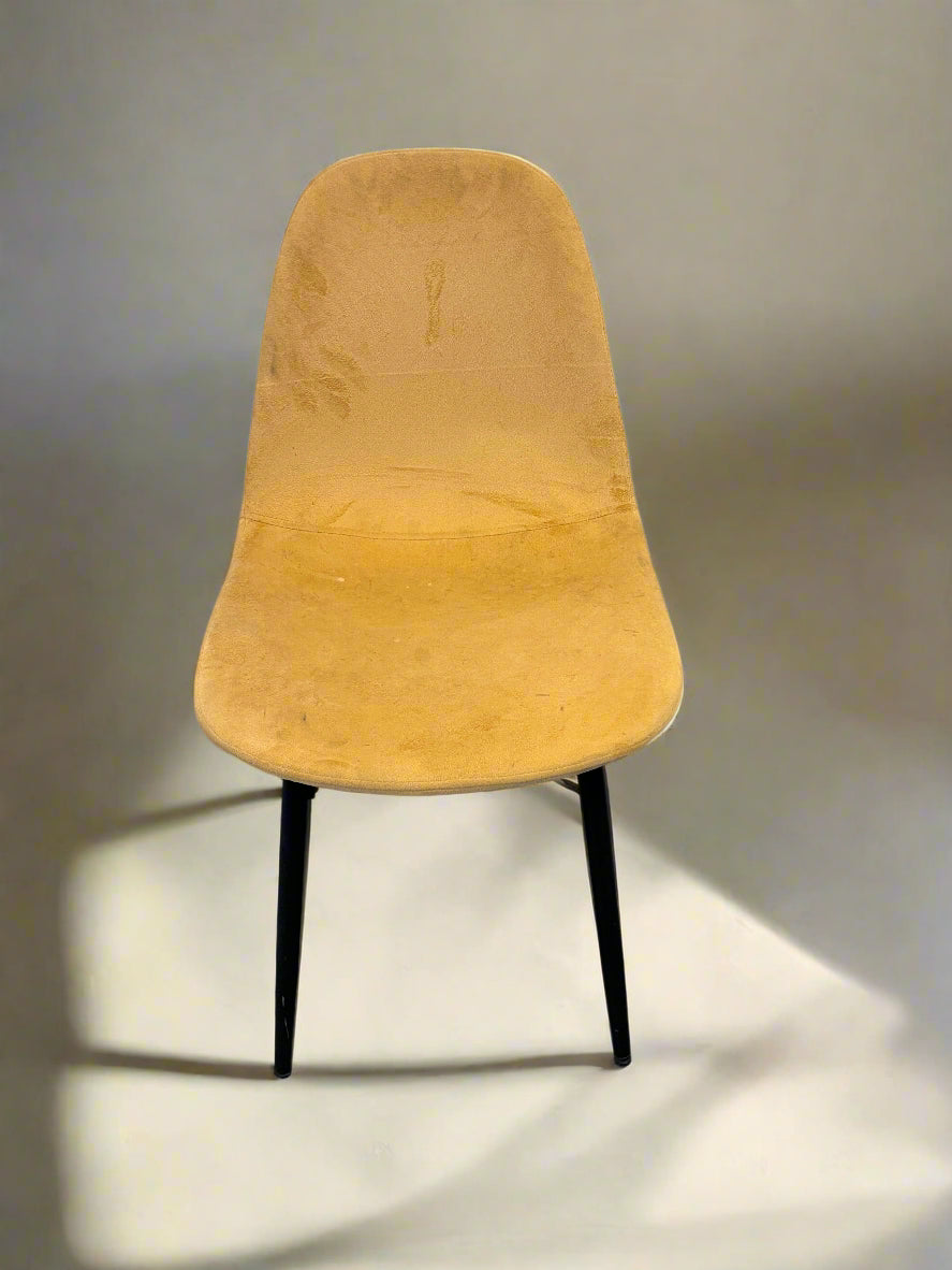 A mid-century yellow upholstered chair with minor wear, featuring a sleek shape and sturdy black legs.