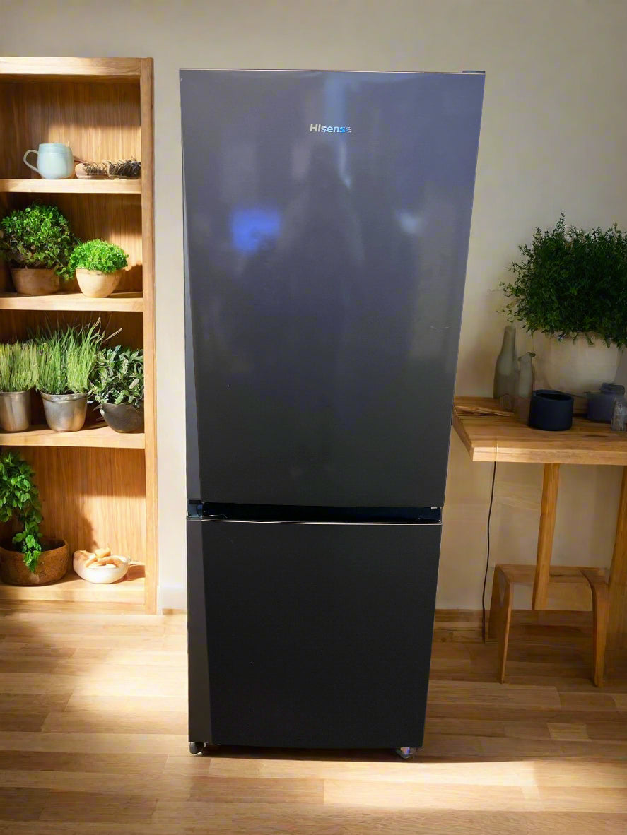 Black refrigerator against a brick wall