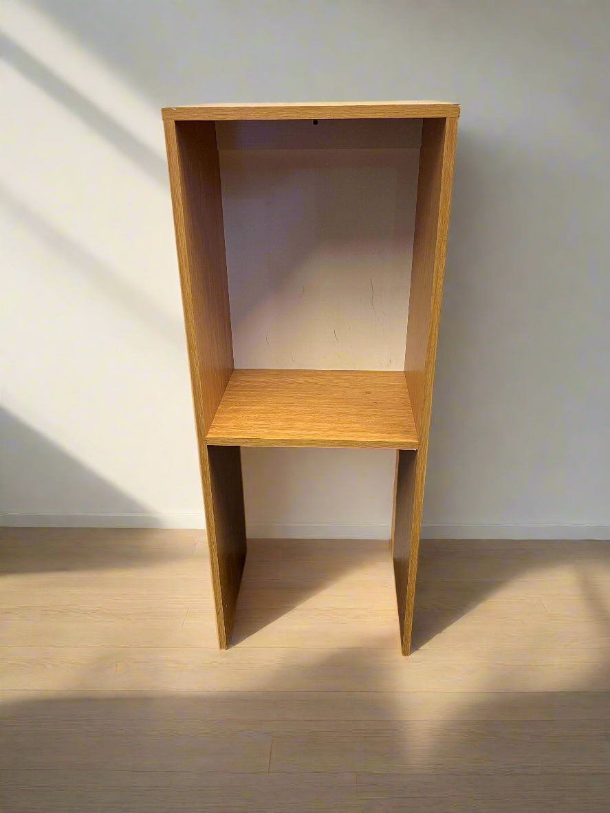 Wooden bookshelf against a brick wall
