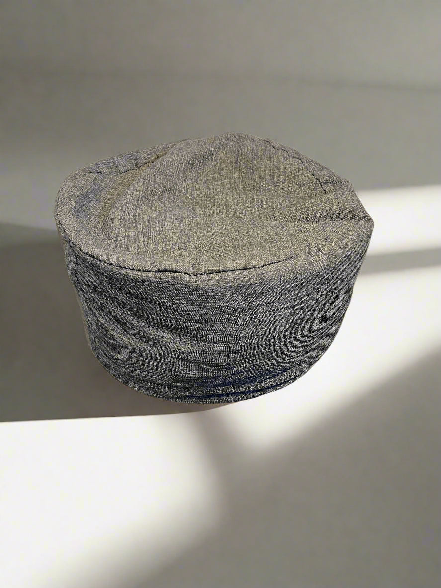 Textured gray hat on a light surface with a soft shadow