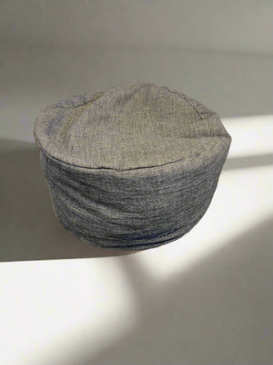Textured gray hat on a light surface with a soft shadow