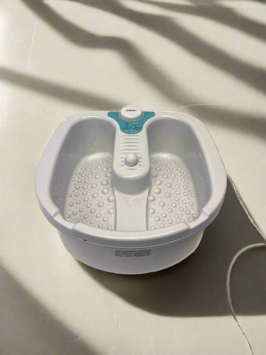 White foot bath with control panel on a light-colored floor