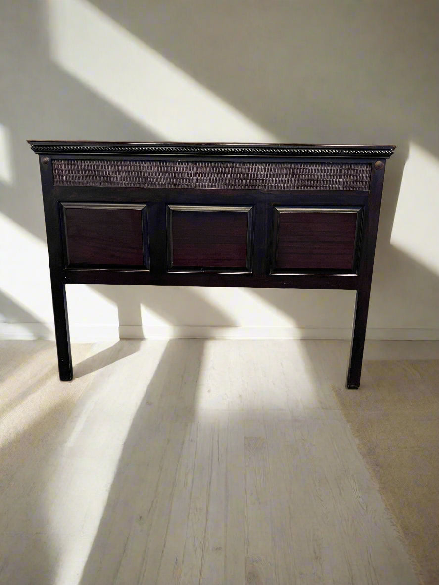 Dark wooden headboard with three square panels on a light wooden floor.