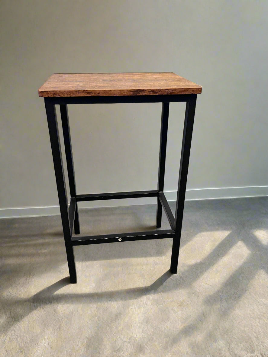 Small wooden table with black metal frame against a gray wall.