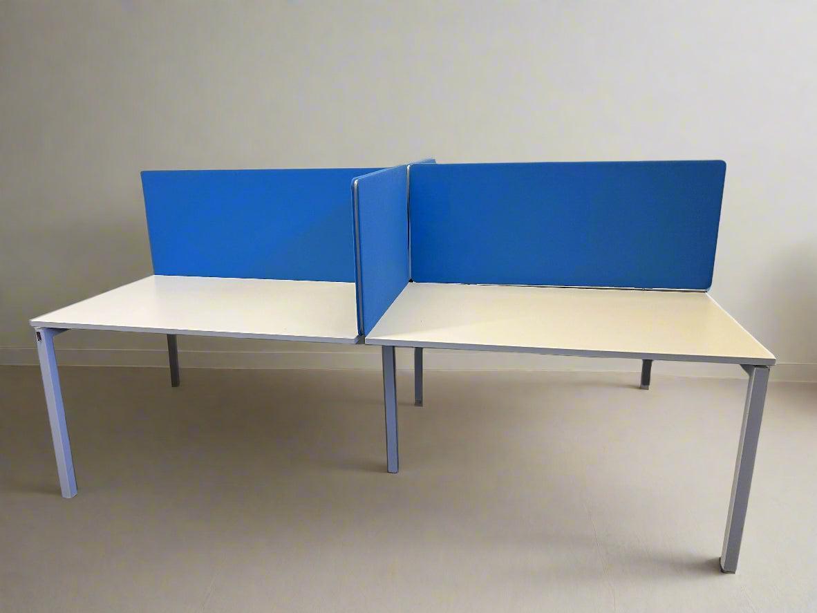 Two desks with blue partition panels on a plain background