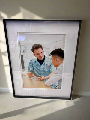 Framed photograph of two people in a professional setting