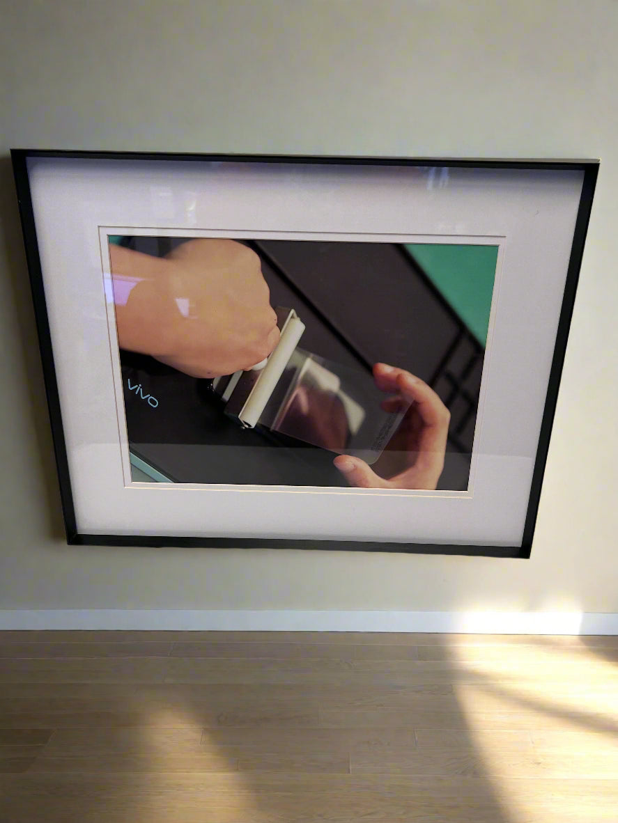 Framed picture of a hand holding a razor with a blurred background
