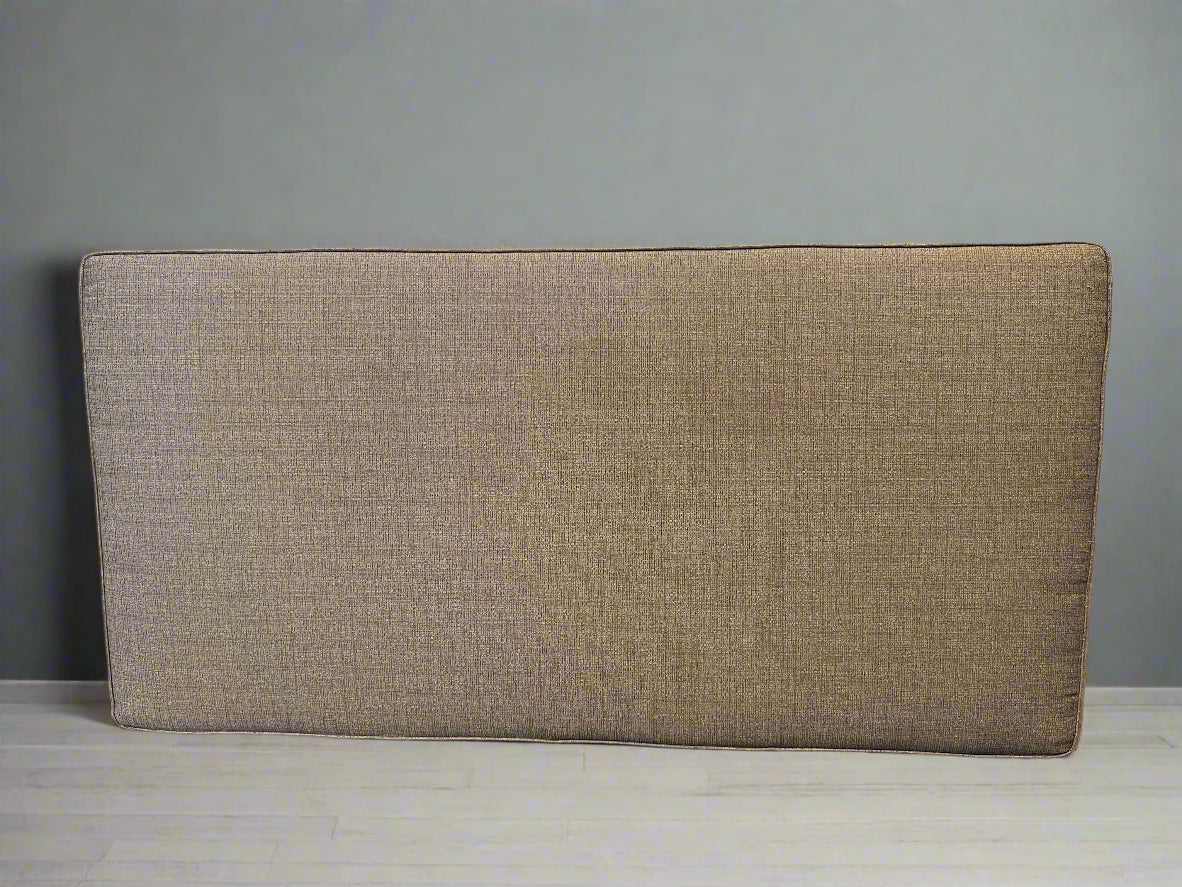 Beige upholstered headboard against a gray wall