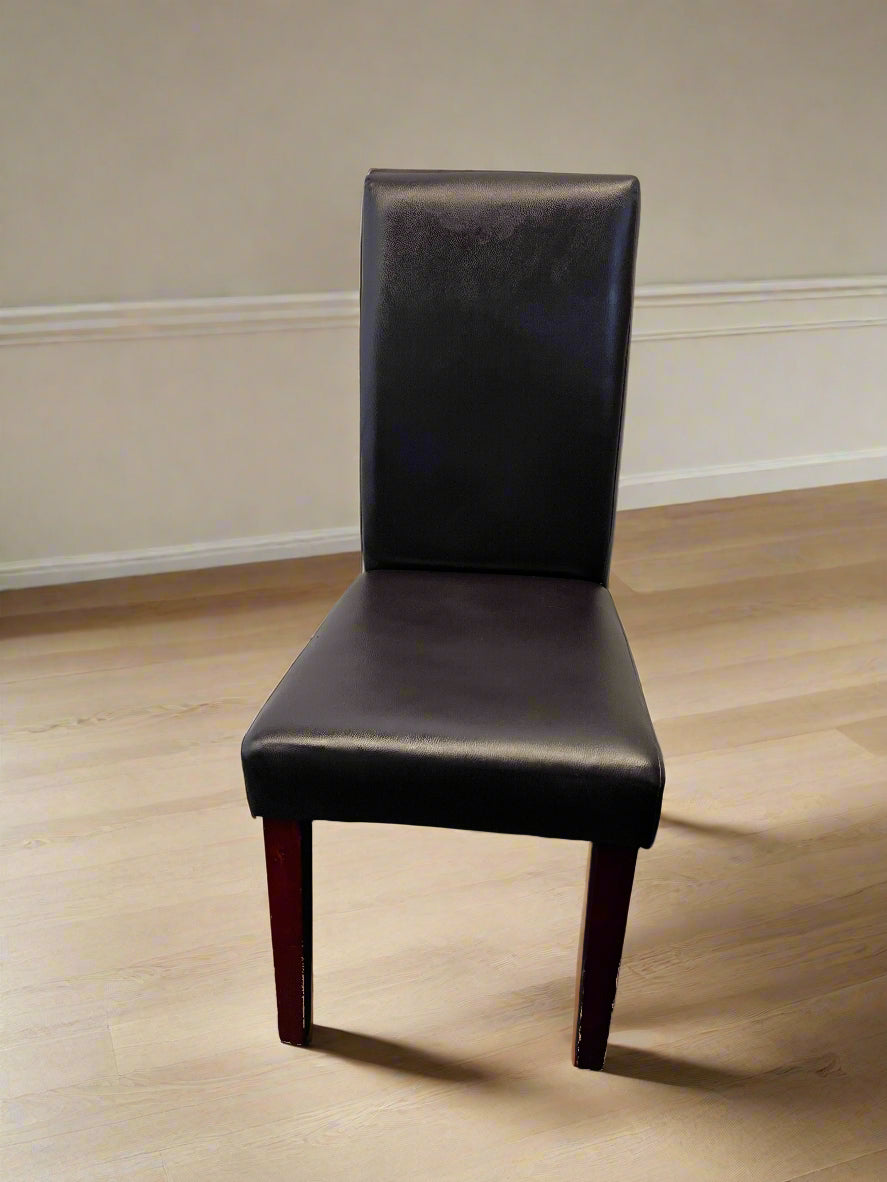 Black leather chair on a wooden floor with a neutral wall background