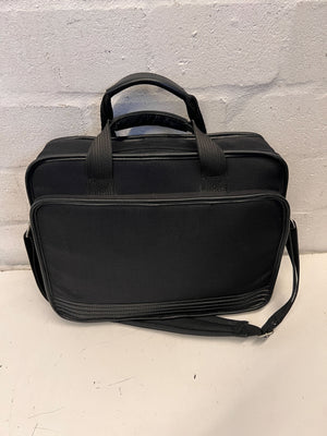 Black briefcase on a light gray surface with a light gray textured background