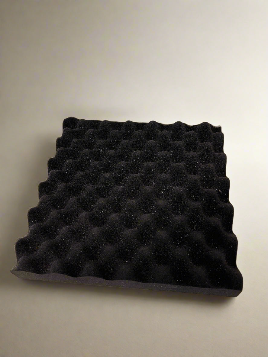 Black quilted pillow on a beige background
