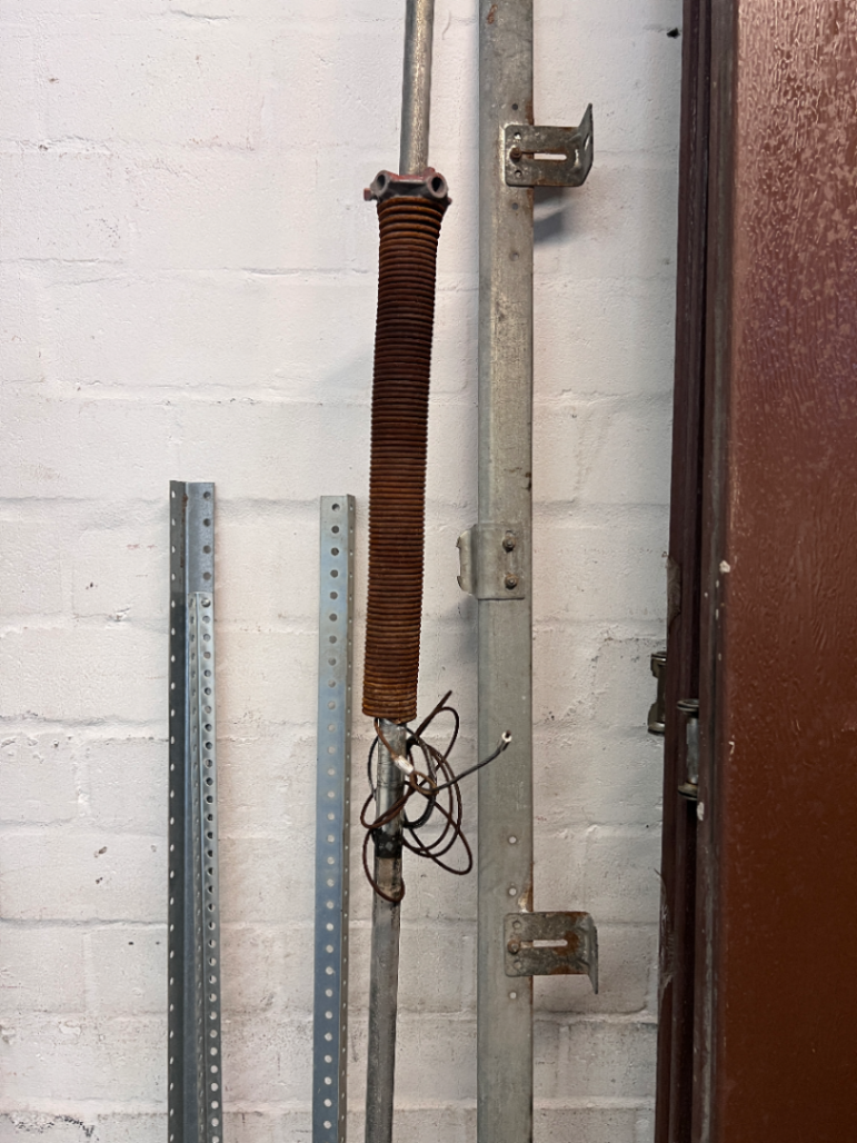 Brown Metal Sectional Garage Door with Motor and Tracks — One Door With Snapped Tensioner; Both Motors Working
