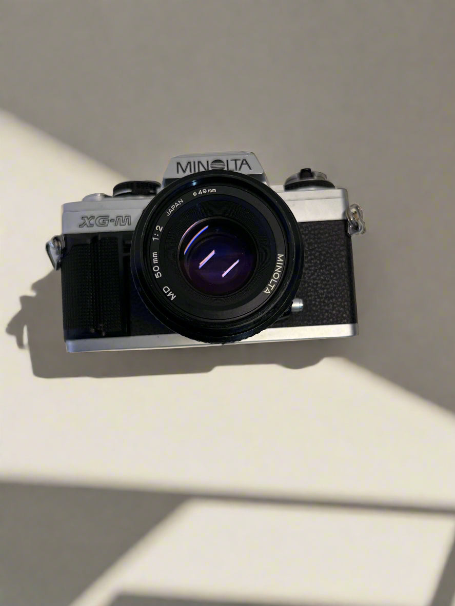 Minolta camera on a light surface with a neutral background