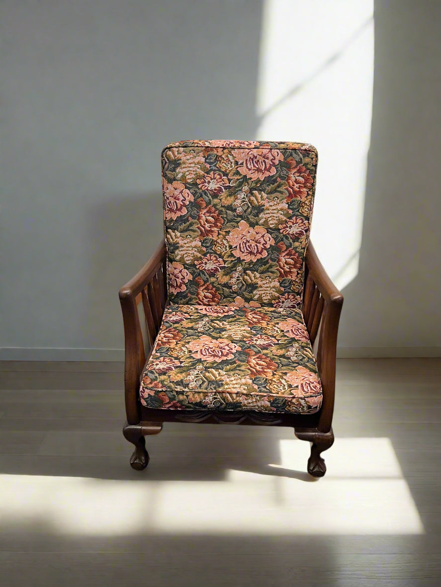 Floral-patterned armchair in a room with sunlight casting shadows on the floor.