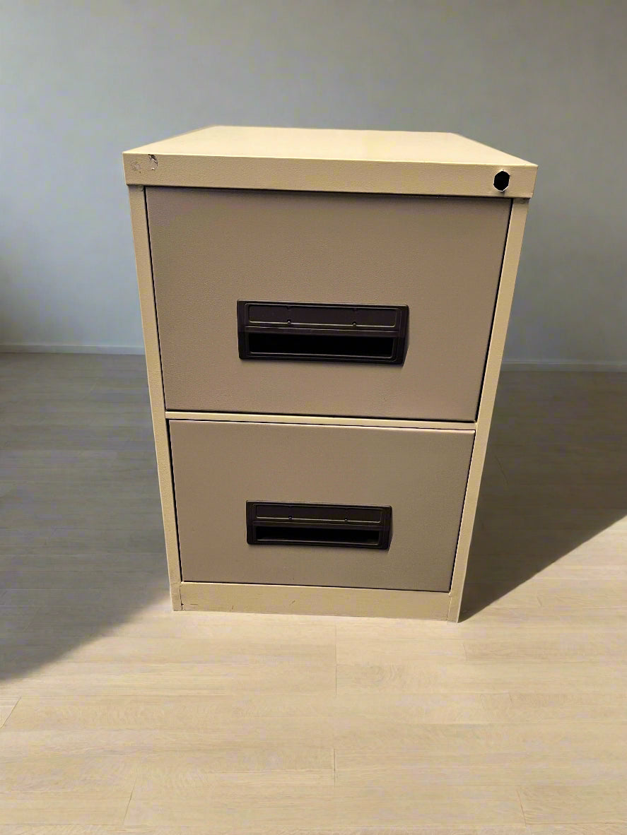 Beige two-drawer filing cabinet against a gray brick wall.