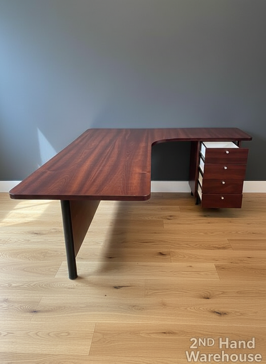 Wooden L-shaped desk with drawers on a wooden floor against a gray wall, labeled '2nd Hand Warehouse'.