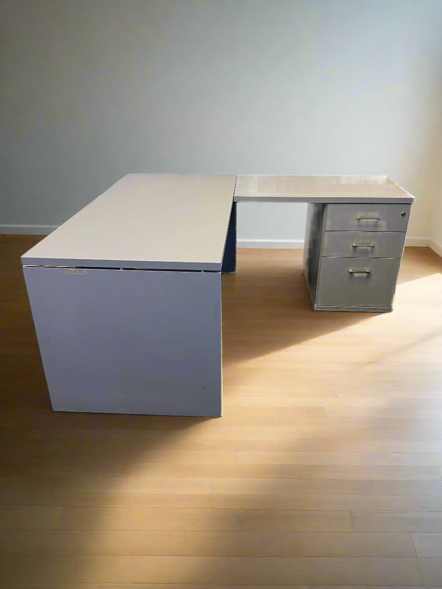 Gray L-shaped desk with a white brick wall background