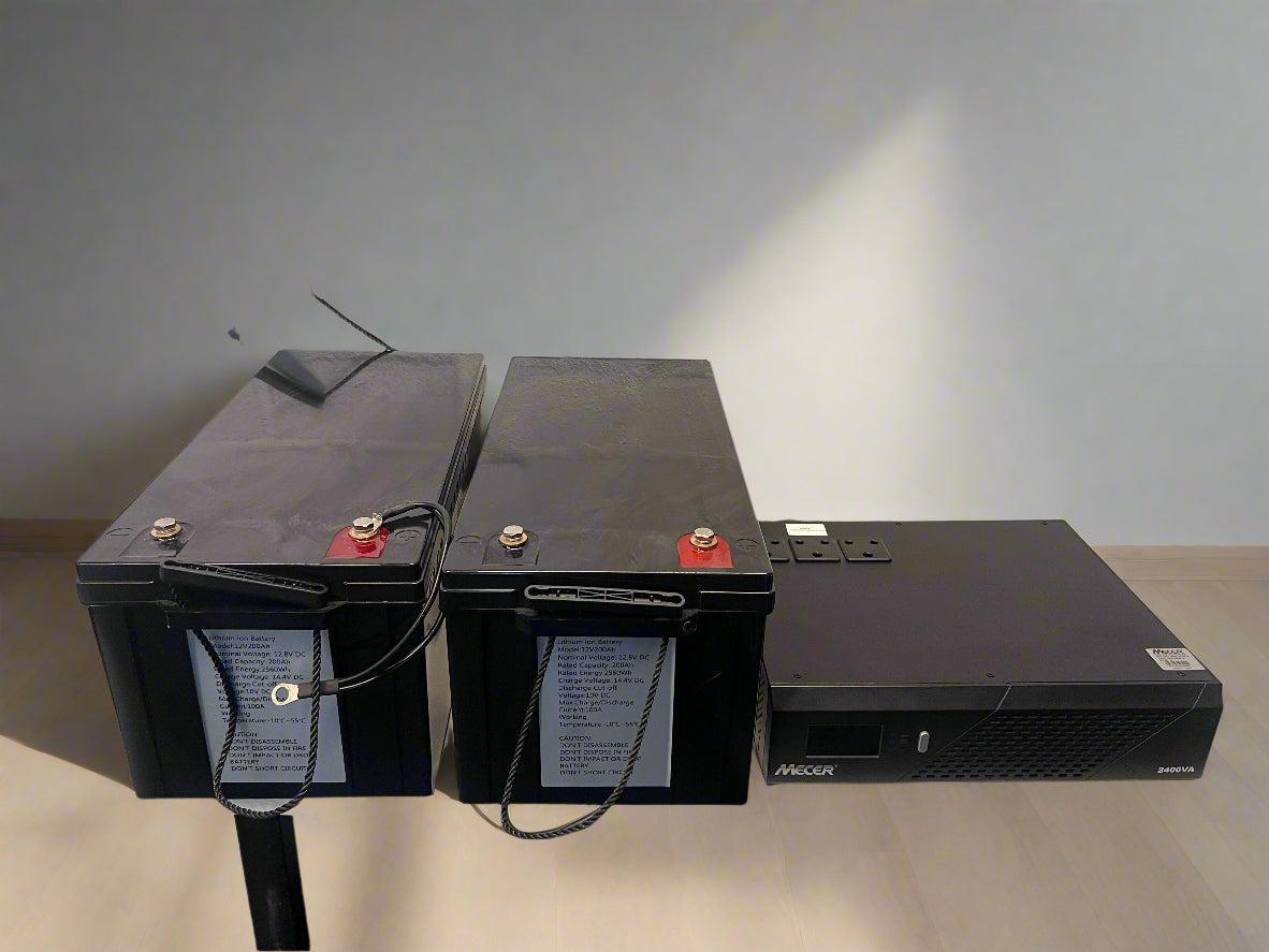 Two black batteries with cables on a light gray background