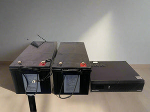 Two black batteries with cables on a light gray background