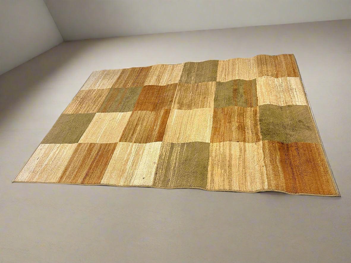 Patchwork rug with brown and beige tones on a plain background